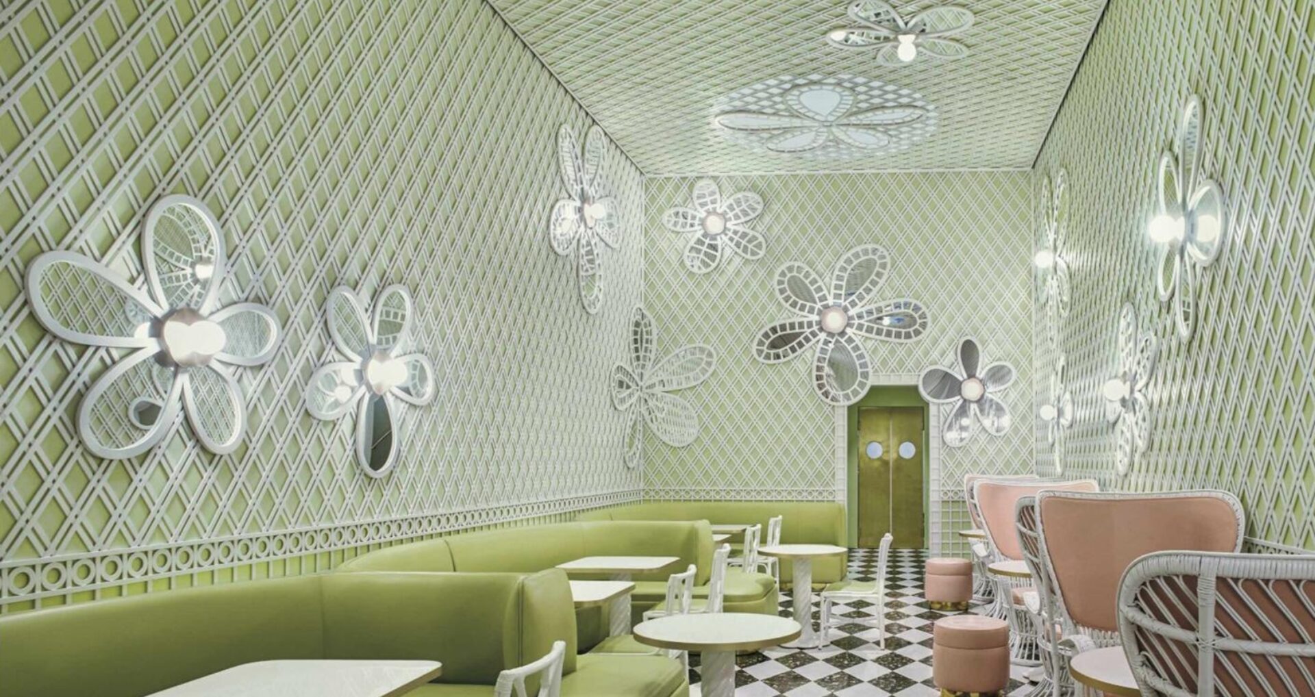 A vibrant café interior featuring green patterned walls, whimsical floral decorations, and comfortable seating arrangements.
