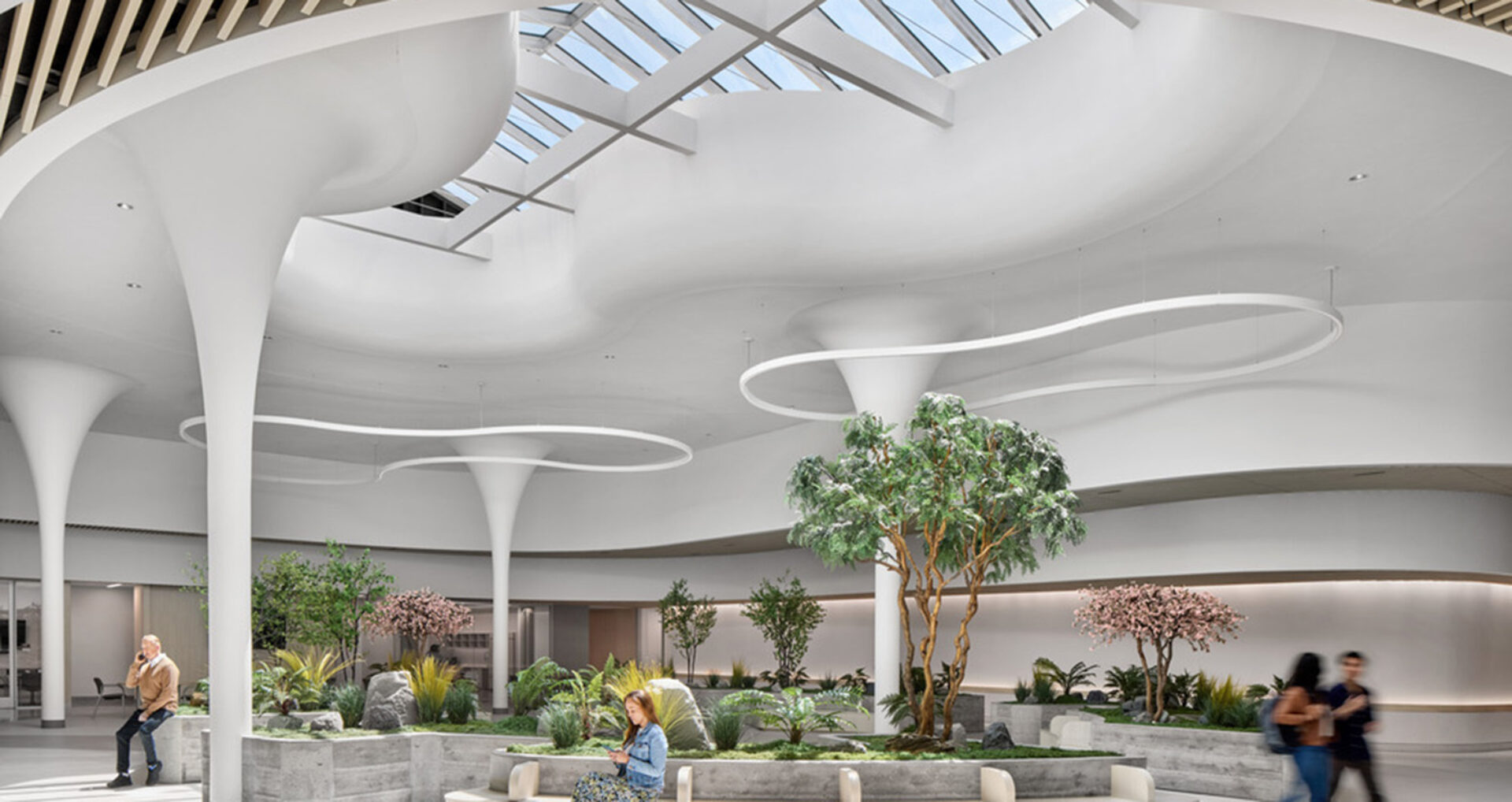 Bright, modern atrium featuring sculptural white ceilings, greenery, and contemporary seating areas, promoting a calming atmosphere.