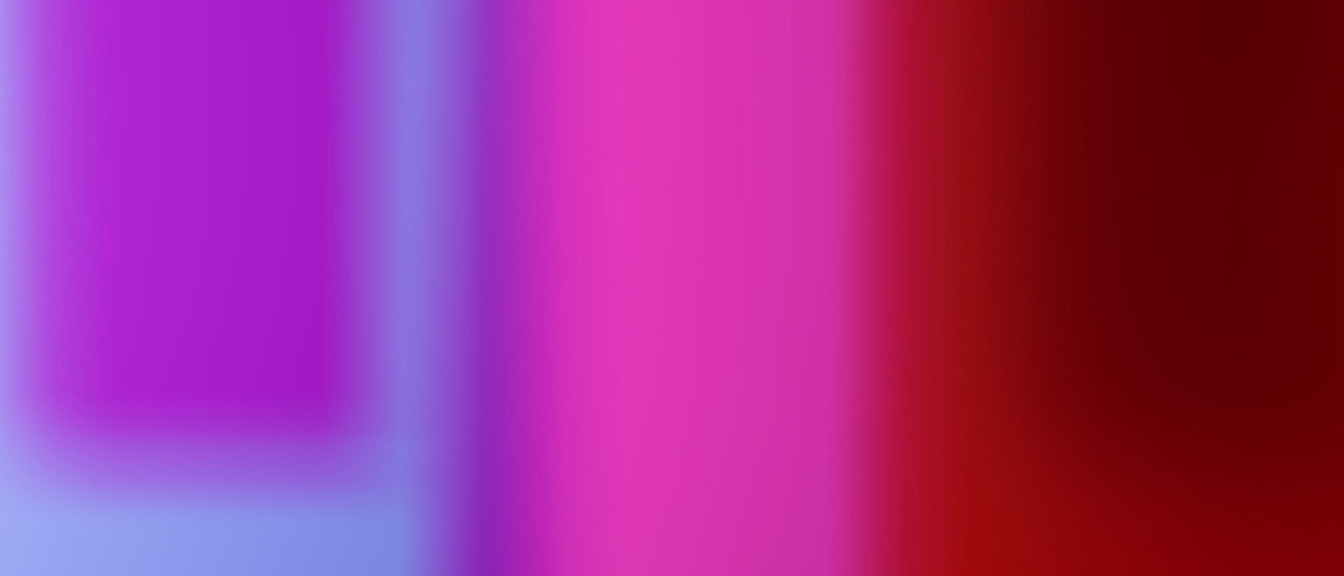 A gradient of vibrant colors transitions from deep purple and blue to bright pink and red, creating a smooth, abstract visual effect.