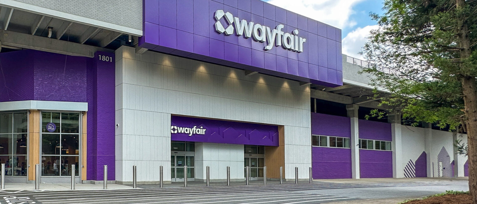 Wayfair's store features a modern exterior with prominent purple branding and a welcoming entrance, surrounded by a parking area.