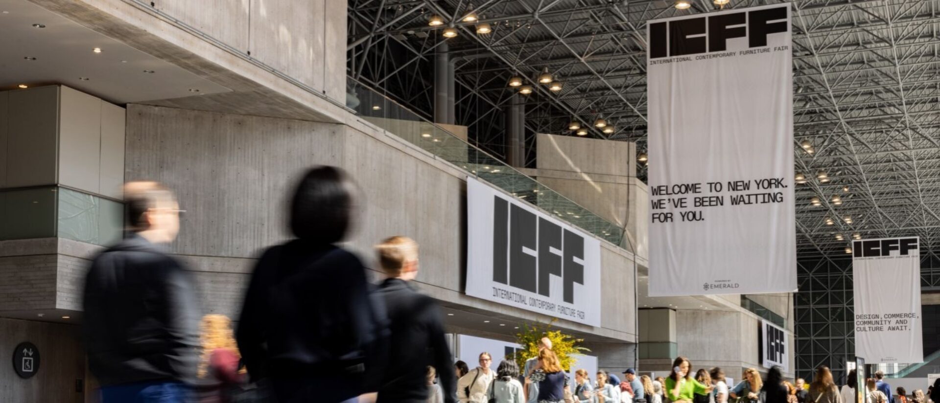 A bustling venue showcases attendees moving through a modern space adorned with banners for the International Contemporary Furniture Fair.