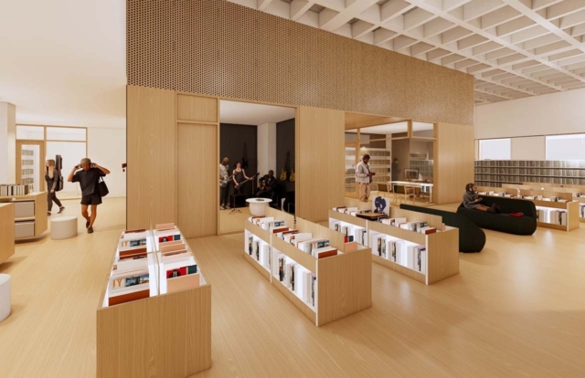 Modern library interior with light wood shelves and grid ceiling, low stacks, black lounges, people browsing and a glass music room.