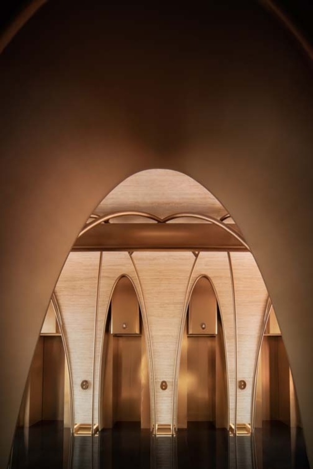 Luxurious interior featuring elegant archways and warm lighting, with sleek elevator doors integrated into the design.