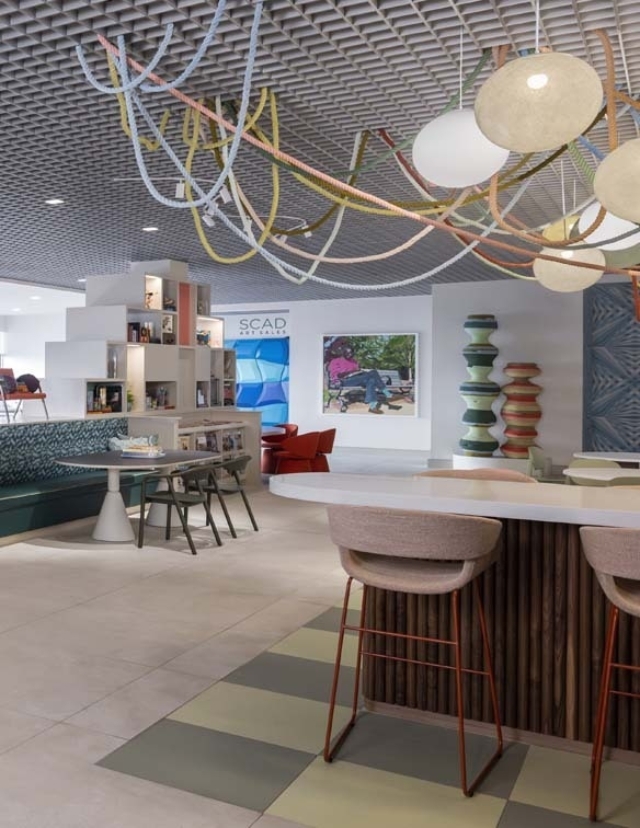 Modern lounge area featuring colorful decor, unique lighting, and seating arrangements, creating a vibrant and inviting atmosphere.