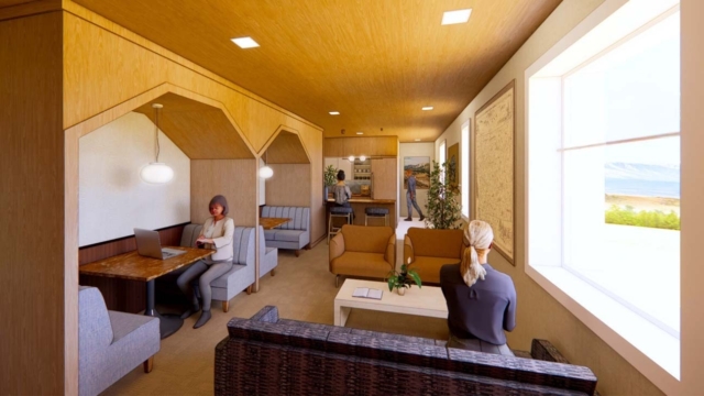 A cozy interior space features diverse seating areas, a workstation, and two people engaged in different activities near bright windows.