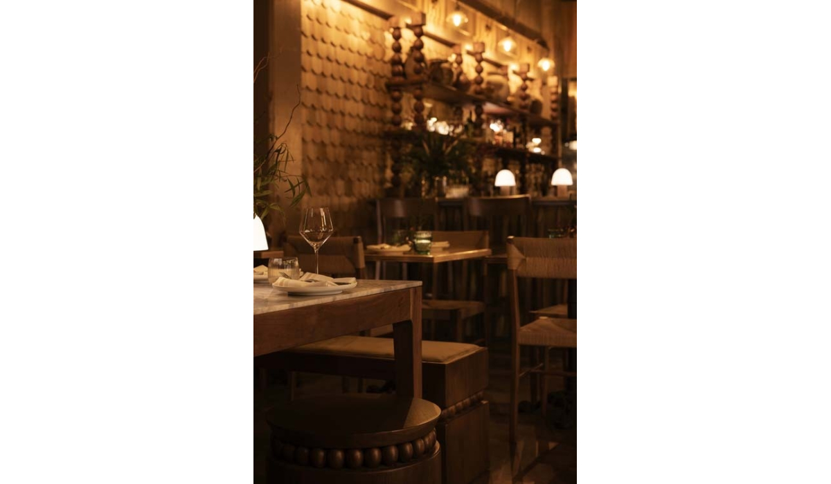 Elegant restaurant interior featuring wooden furniture, soft lighting, and decorative wall textures, creating a warm atmosphere.