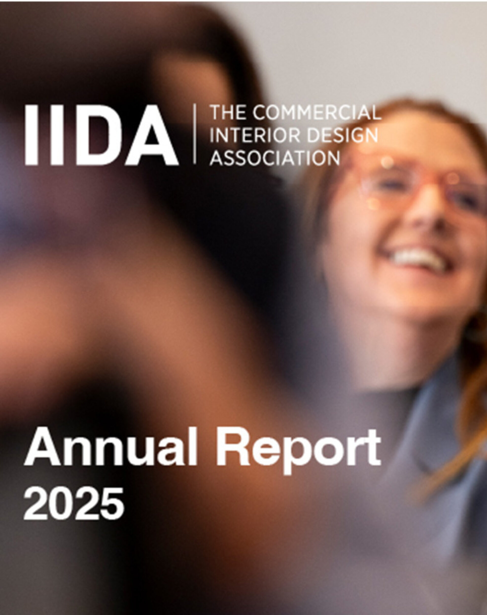 The IIDA logo appears alongside the title "Annual Report 2025," showcasing a smiling individual in a professional setting.
