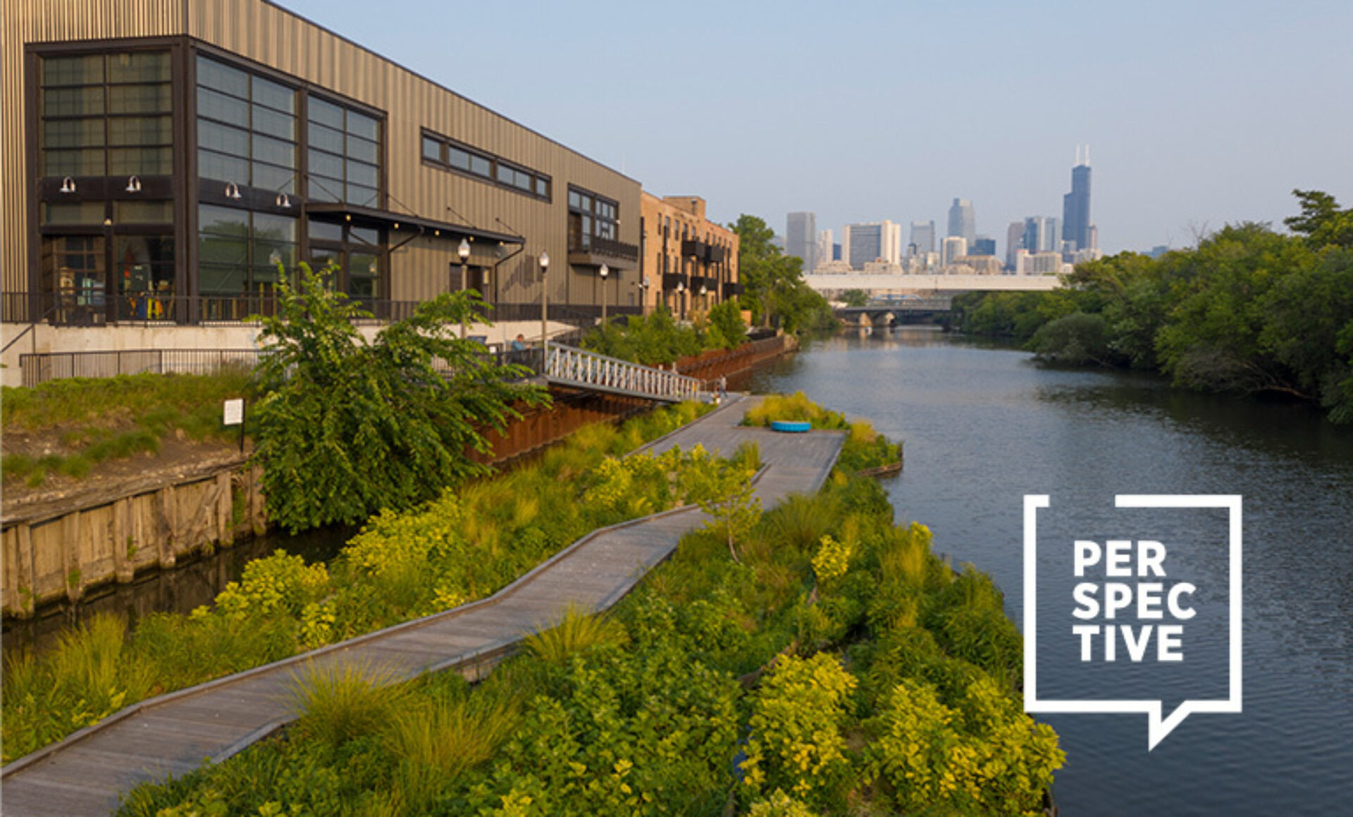 A waterfront scene features a winding wooden path beside a lush shoreline, with modern buildings and the Chicago skyline in the background.