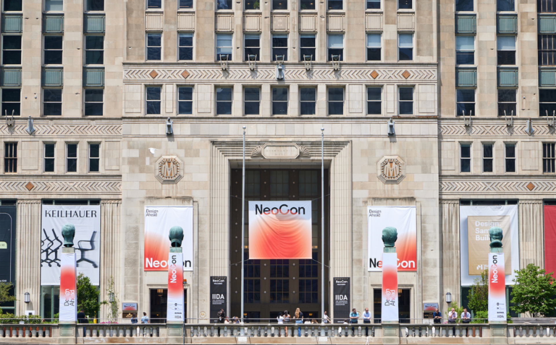 The historic building features bold banners announcing NeoCon, showcasing design elements and a bustling crowd at the entrance.