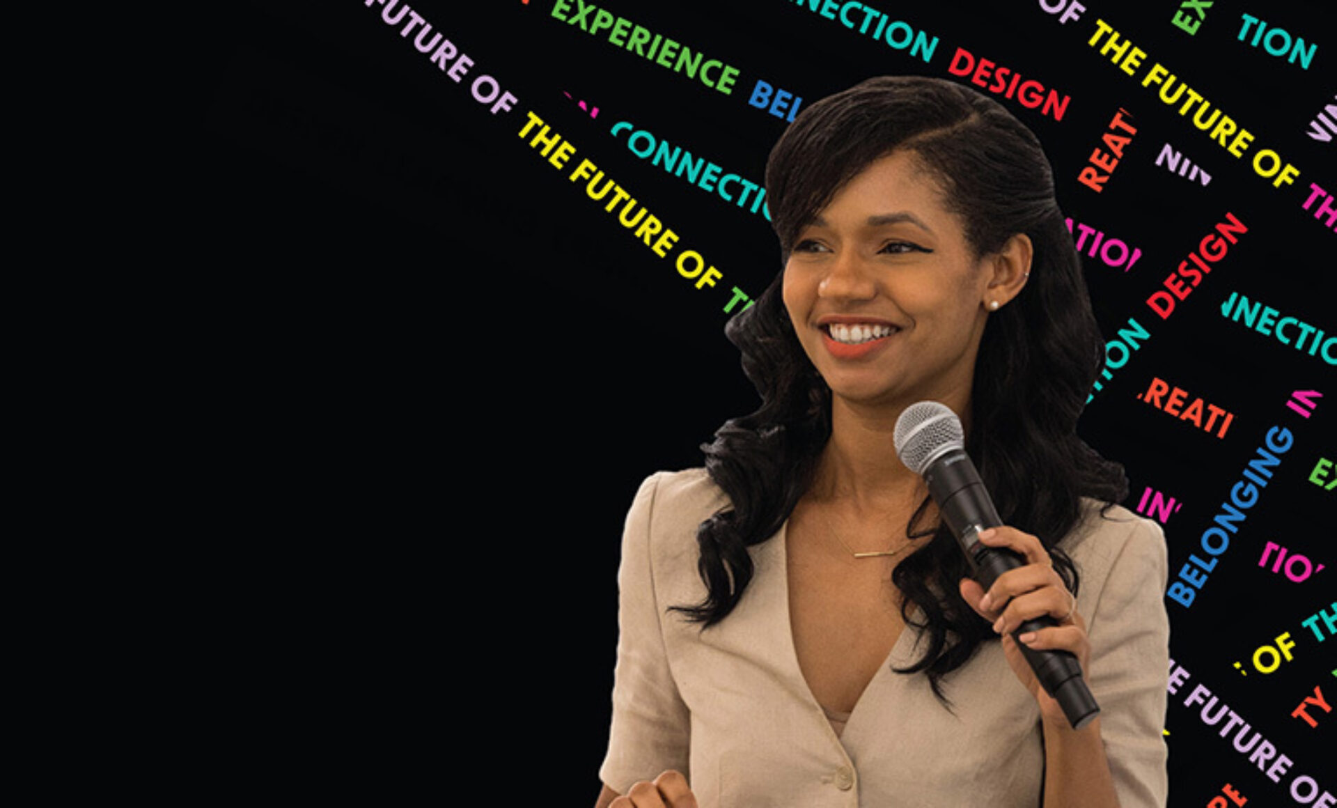 A woman with dark hair smiles while speaking into a microphone against a colorful abstract background featuring words related to design and experience.