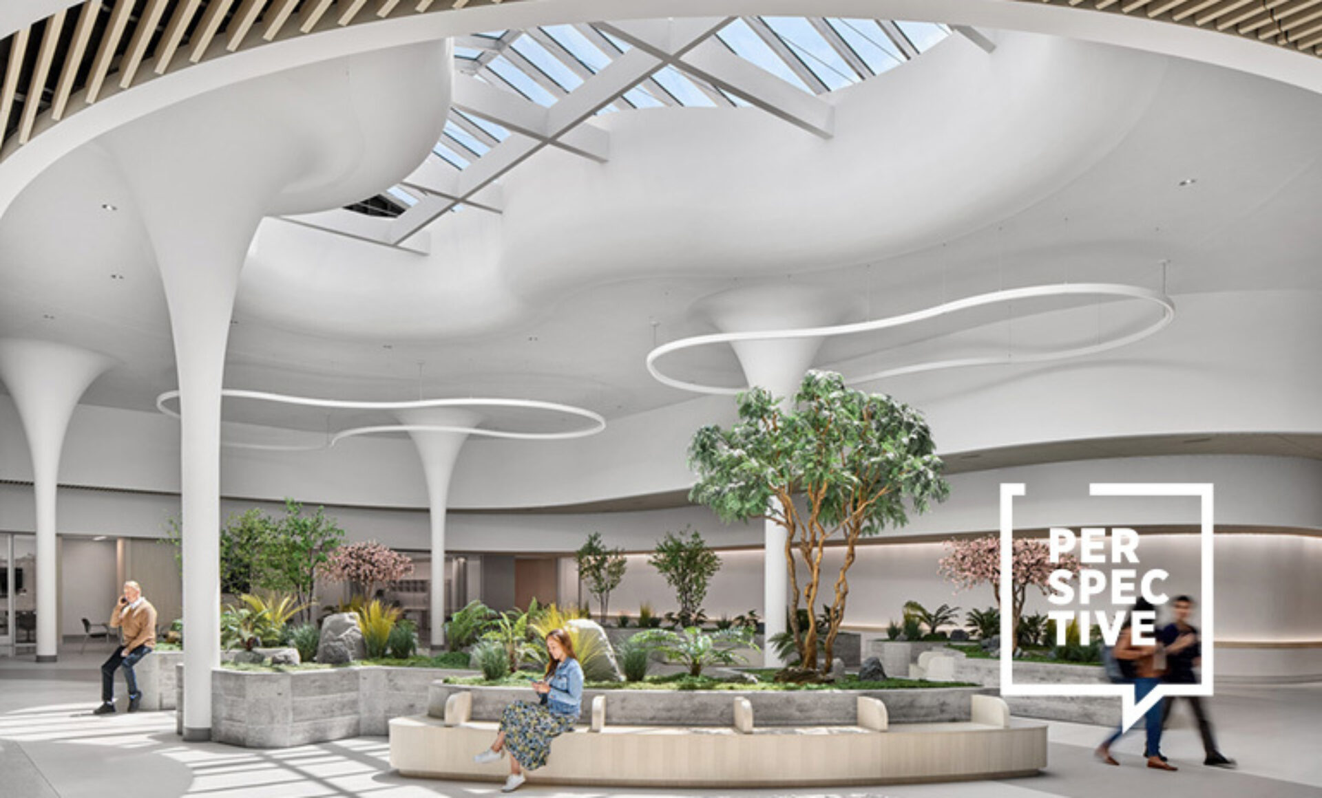 A spacious, modern interior features curved white ceilings, abundant natural light from skylights, and lush greenery throughout.